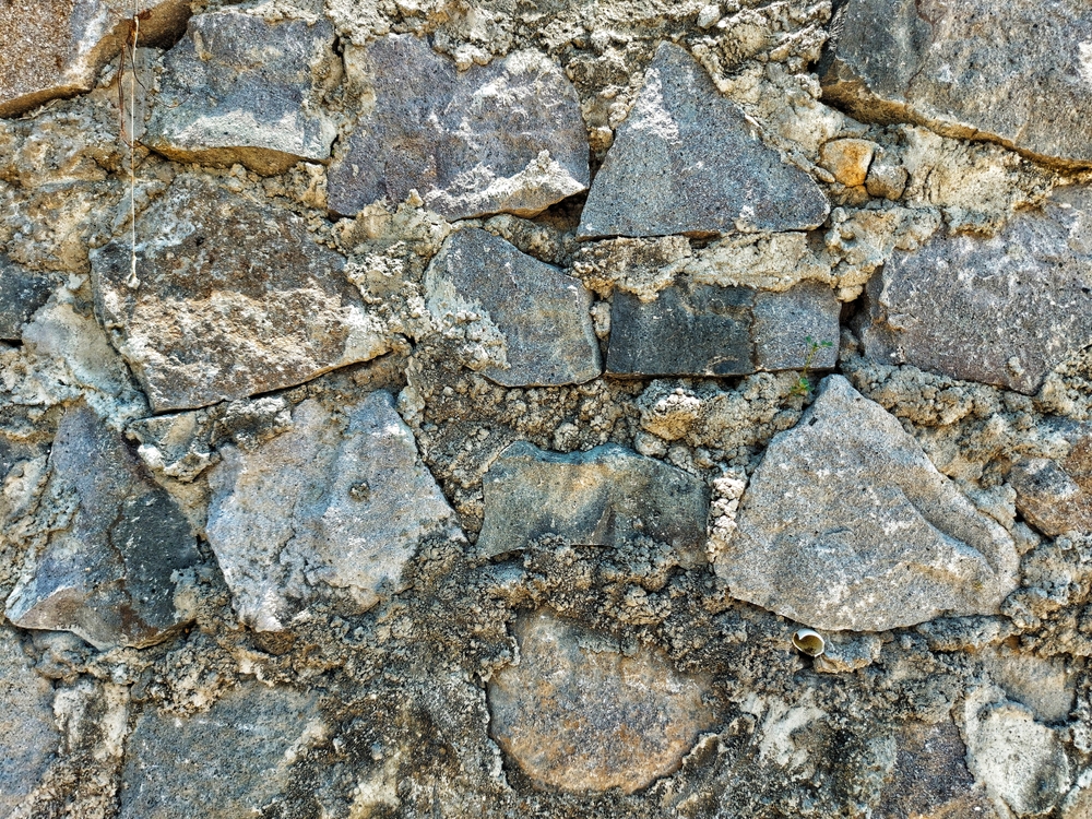 Handbuilt,fieldstone,wall,with,mortar,lines,,moss,hint,and,varied